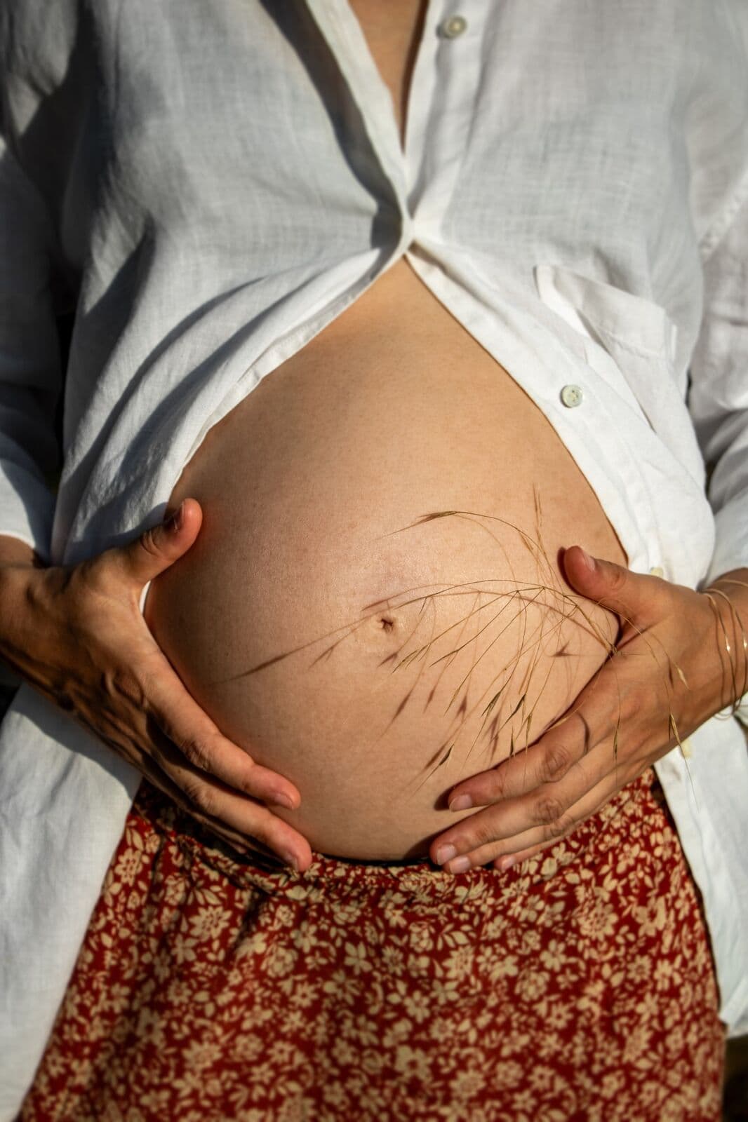 Ventre arrondi d’une future maman, mains posées dessus